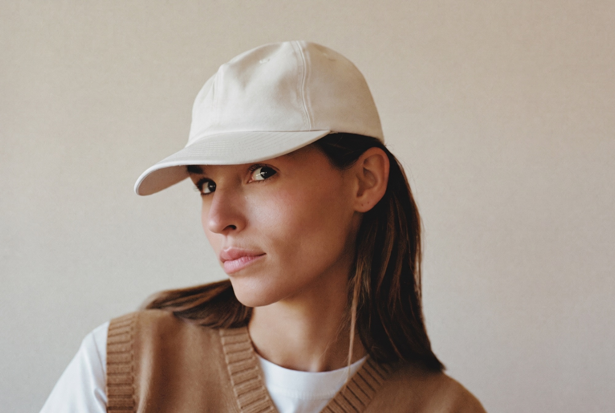 Woman wearing a completely blank cream cap, ready for your label
